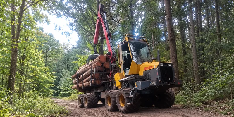 Rückemaschine beim Transport von Baumstämmen im Wald